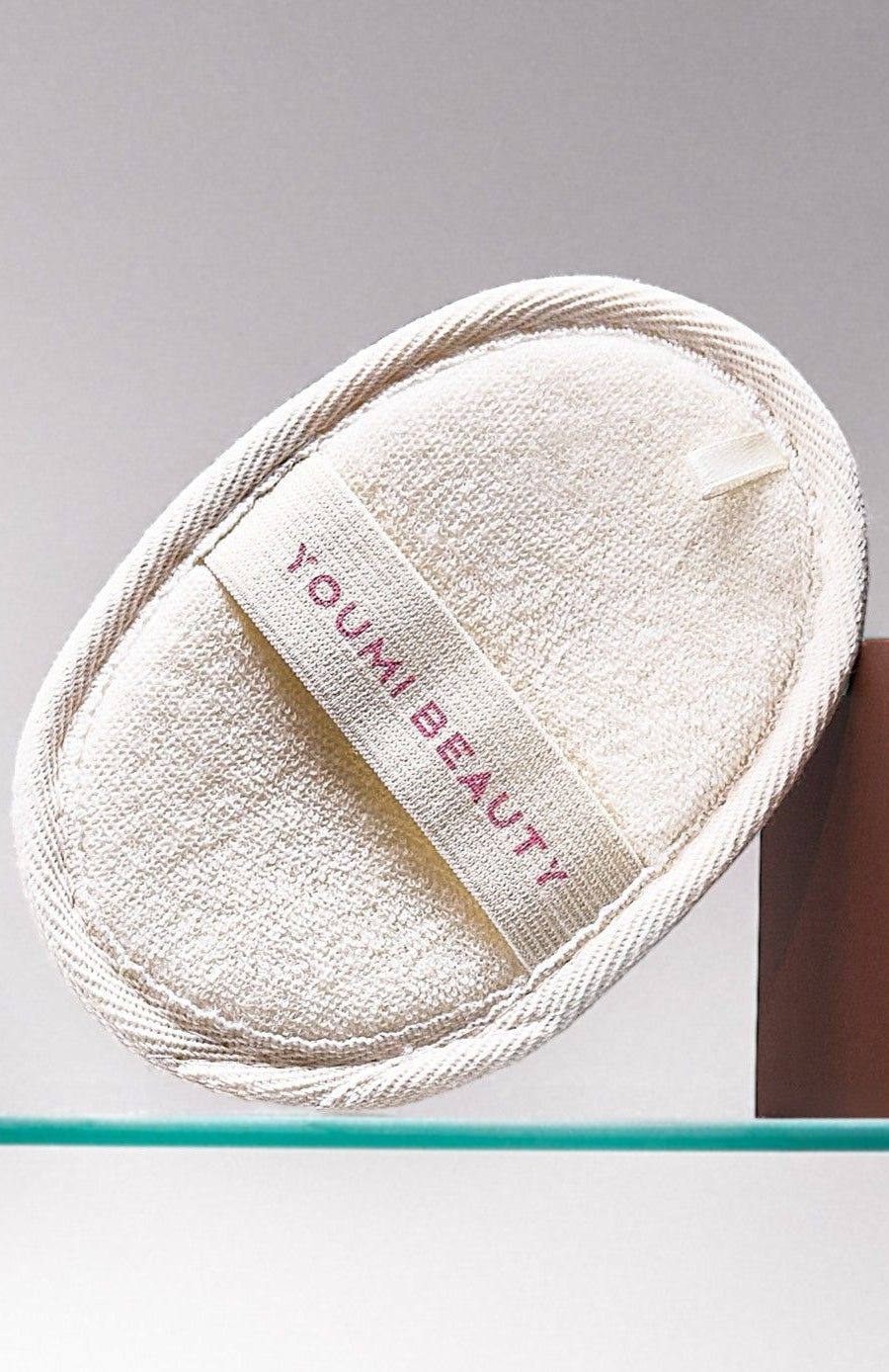 White Loofah with 'Youmi Beauty' label on a gray background